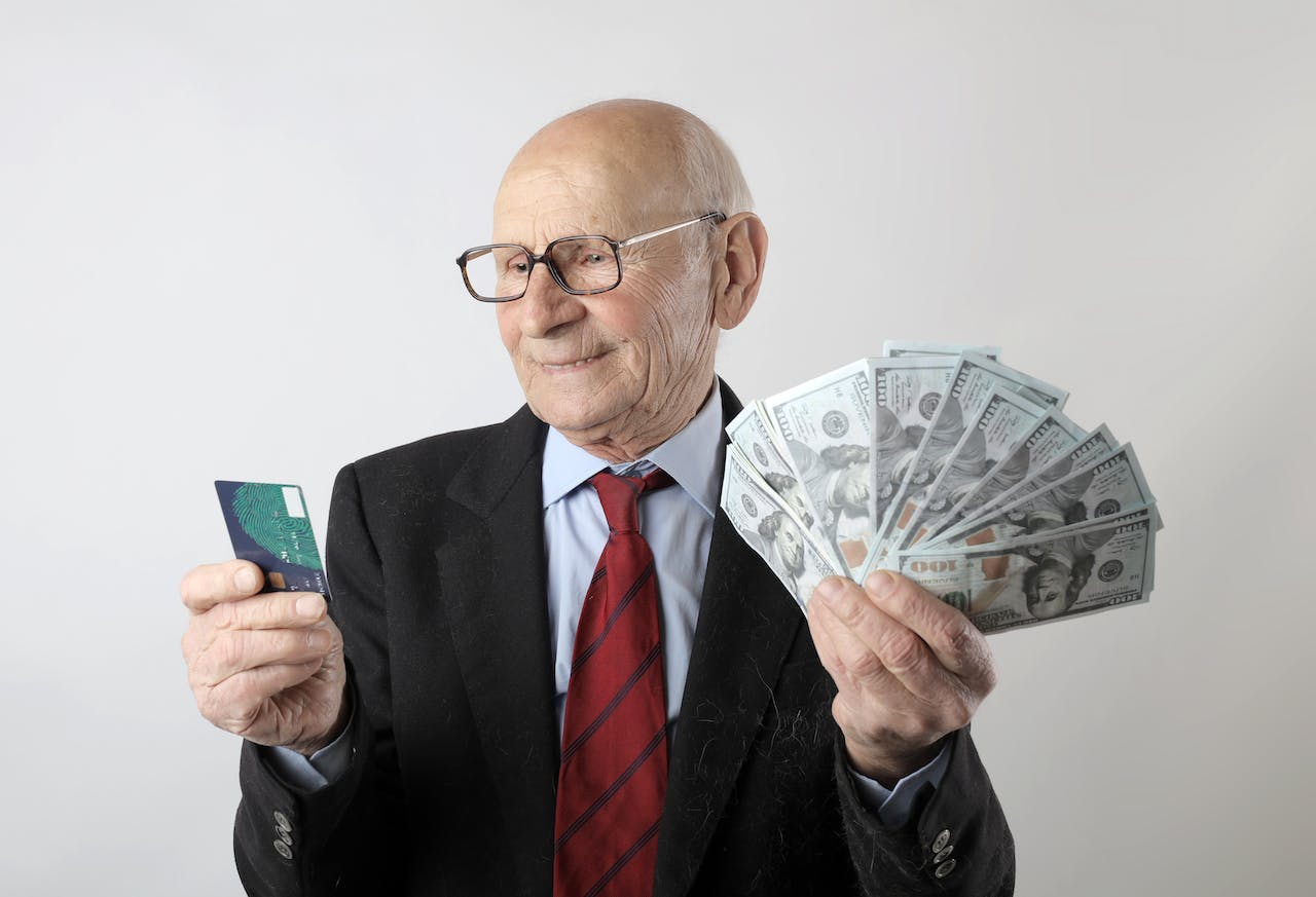 Man In Black Suit Holding Banknotes And Credit Card