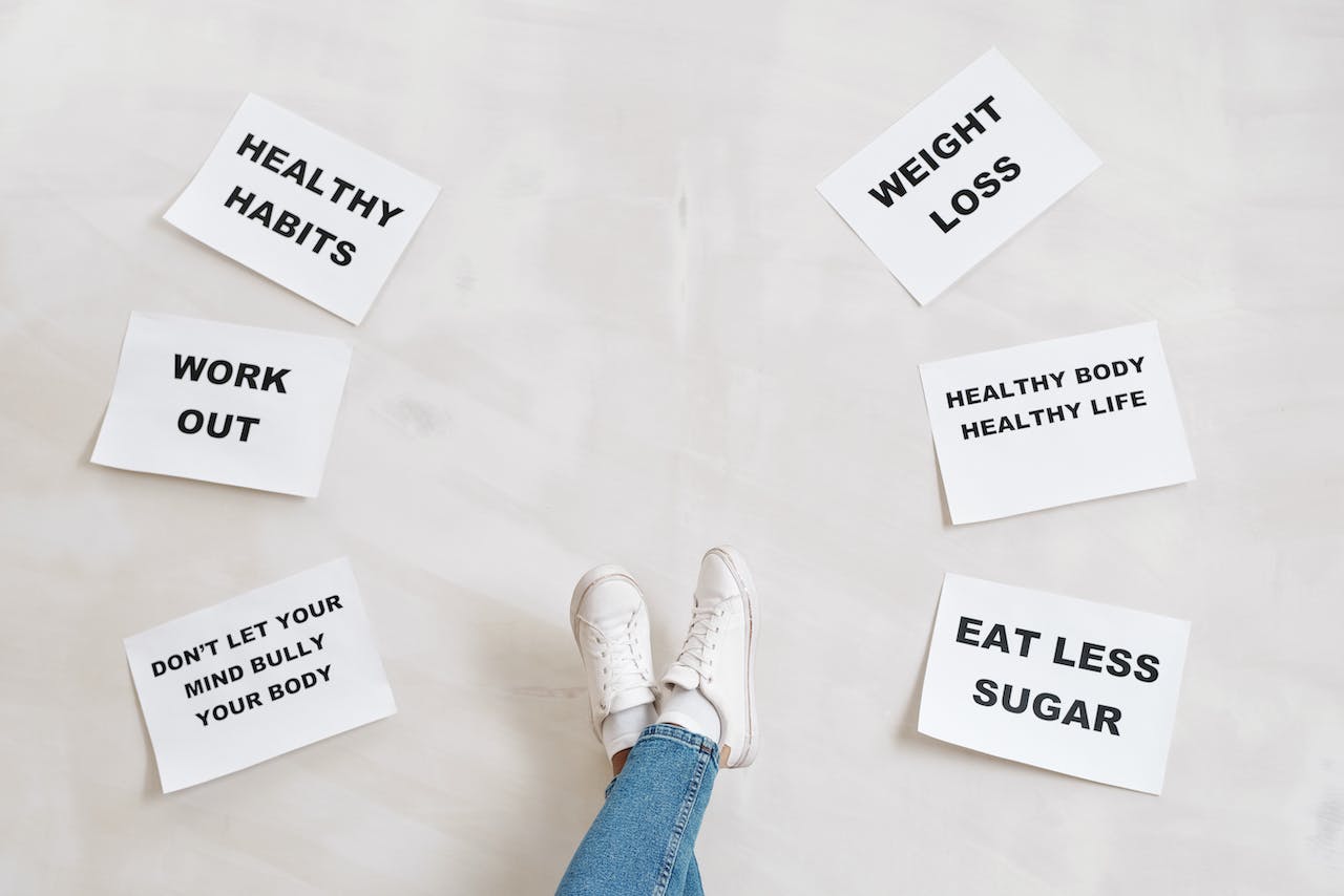 Person Legs with Motivational Words on Papers on White Background