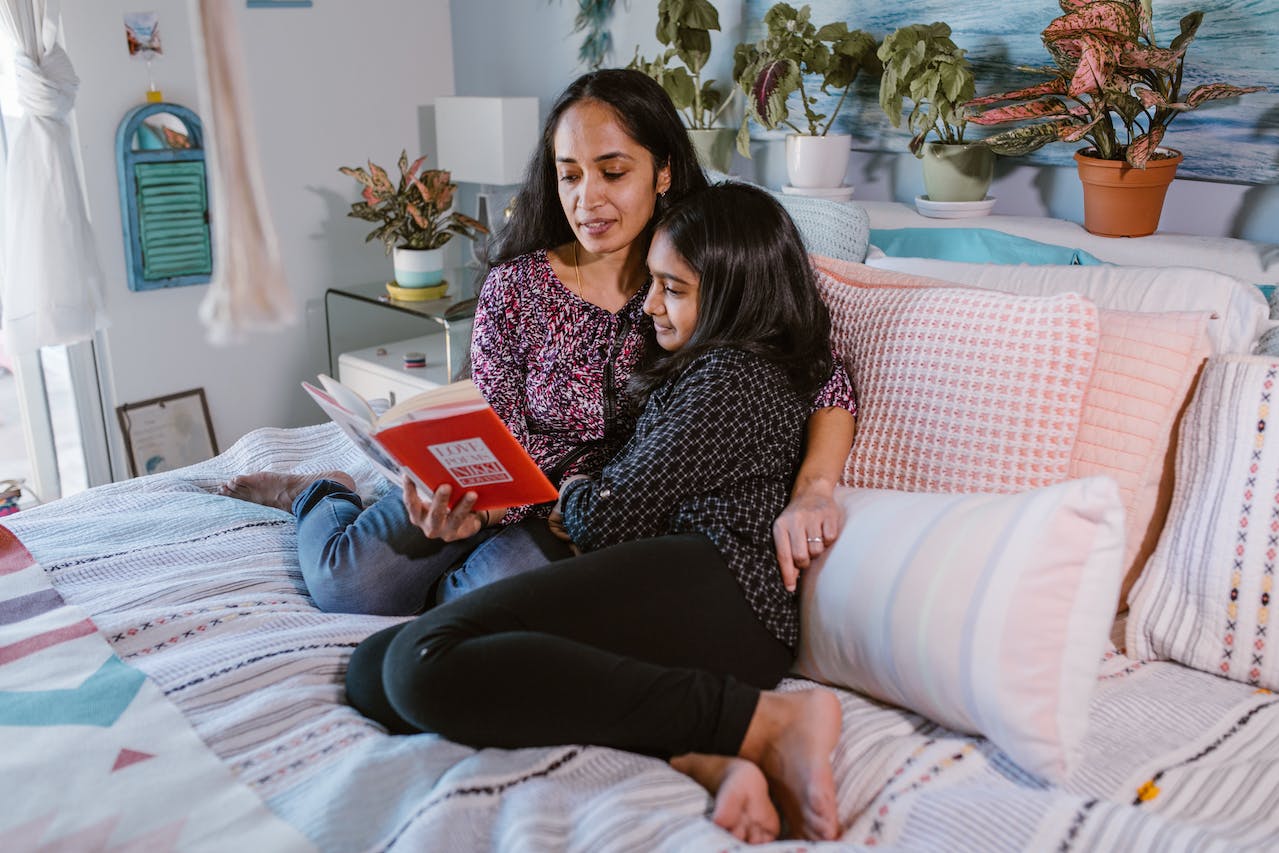 A Woman Reading a Book Together with her Daughter