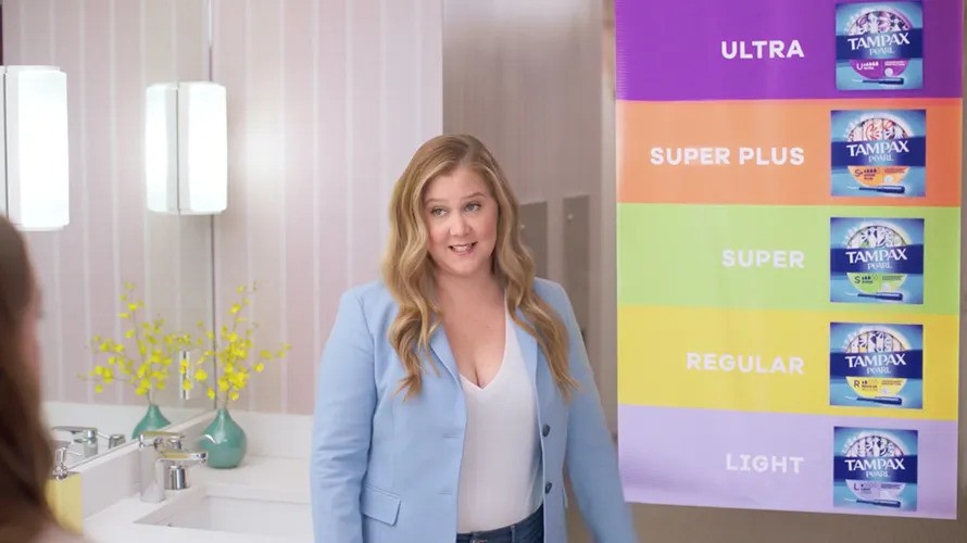 Amy Schumer in a room talking about tampax