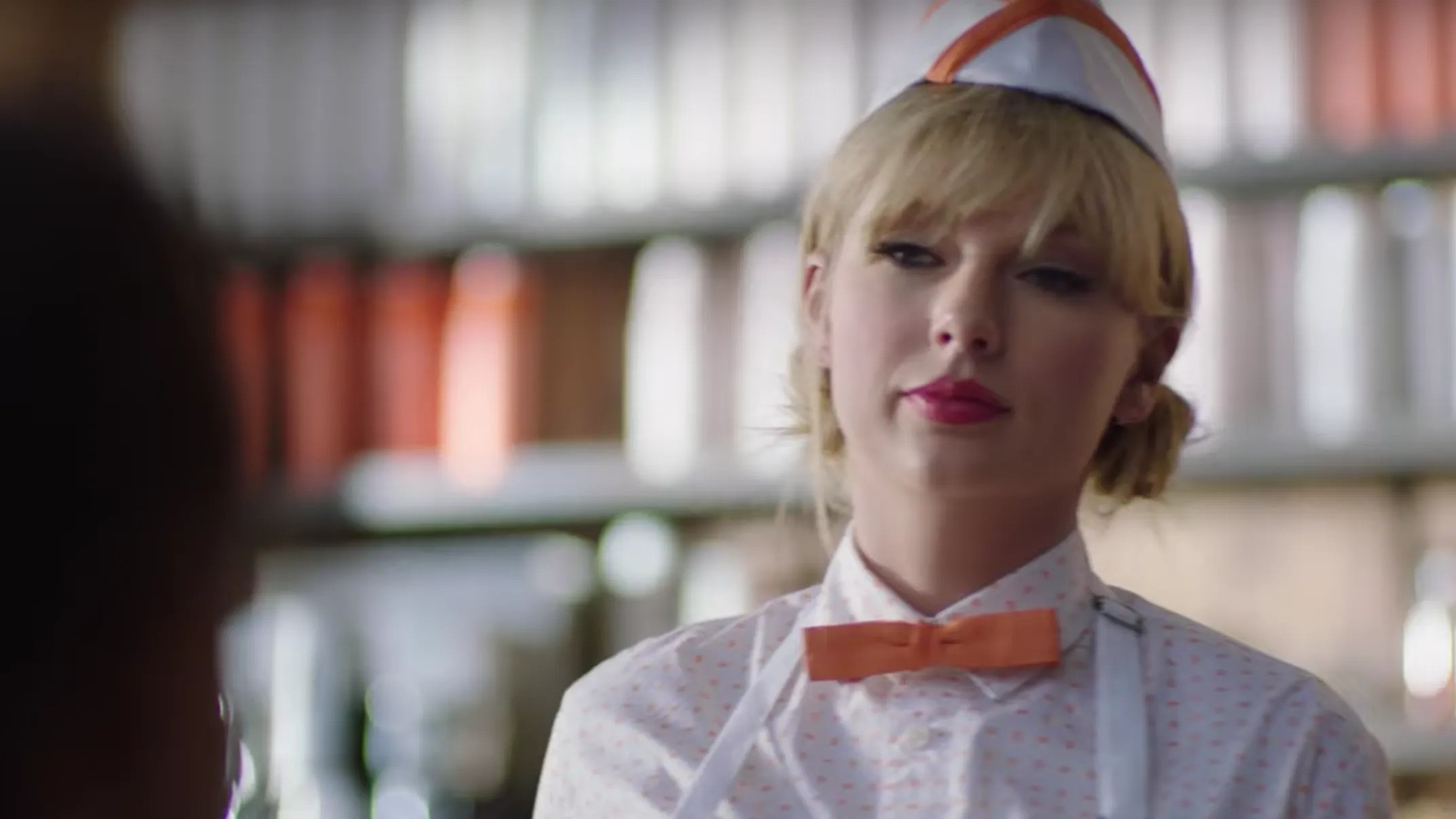 Taylor Swift dressed as a waiter in a video commercial